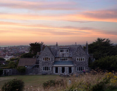 Florence House, Seaford at Sunset. Shows the back of the house with the 3 sets of doors open to the garden