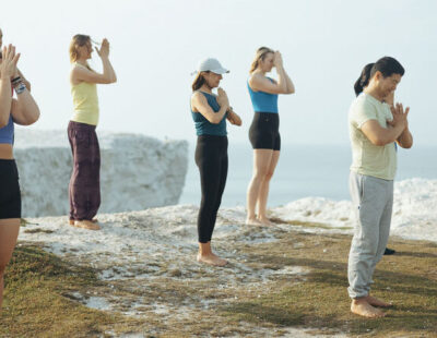 People participating in a yoga session on cliff by Florence House Seaford