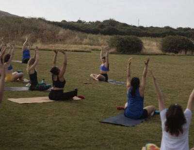 People sat on mats doing yoga in the grounds of Florence House Seaford.